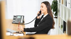A telecom administrator at a desk with multiple monitors managing a VitalPBX system